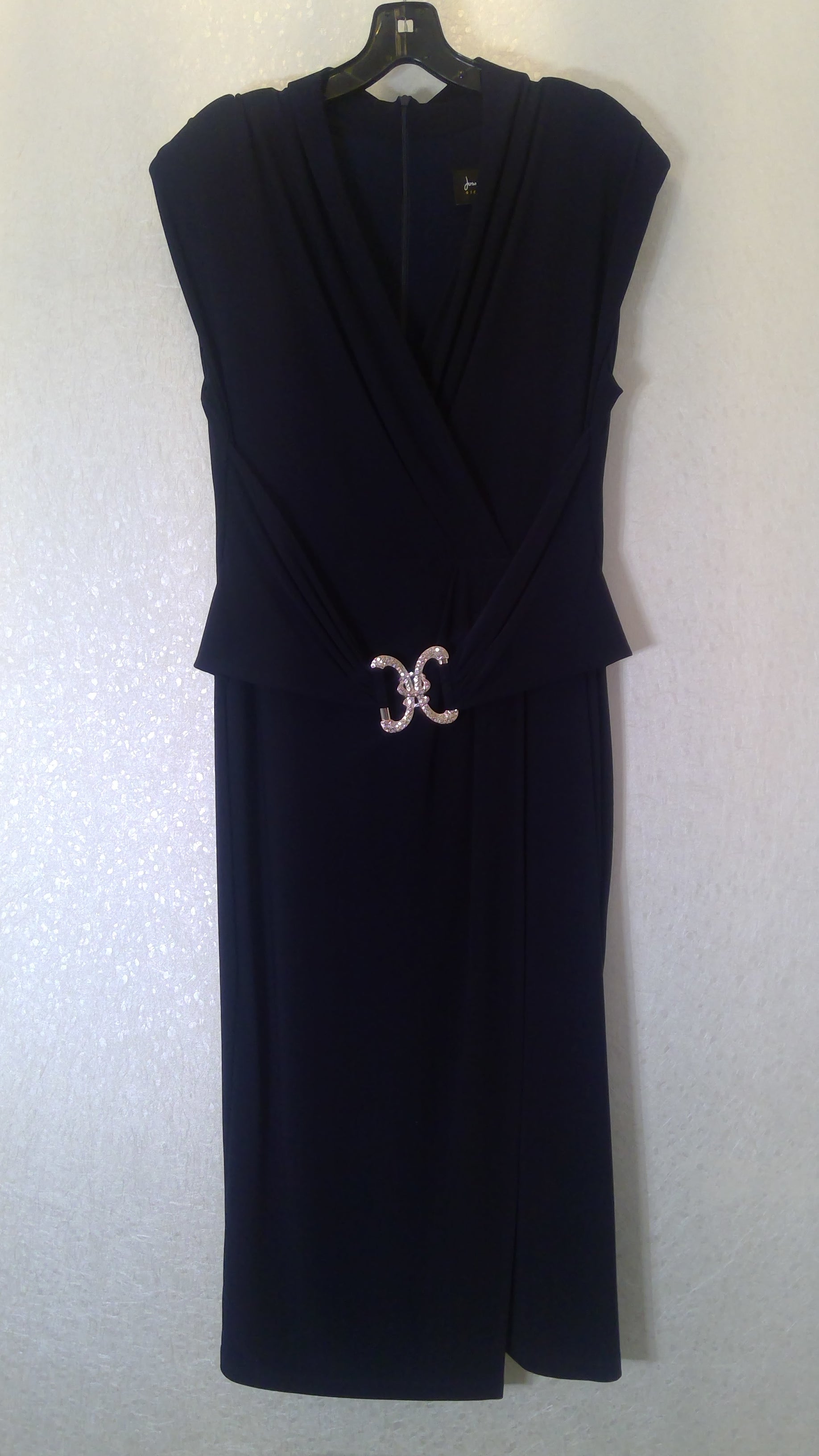 Sleeveless black dress with a gold emblem